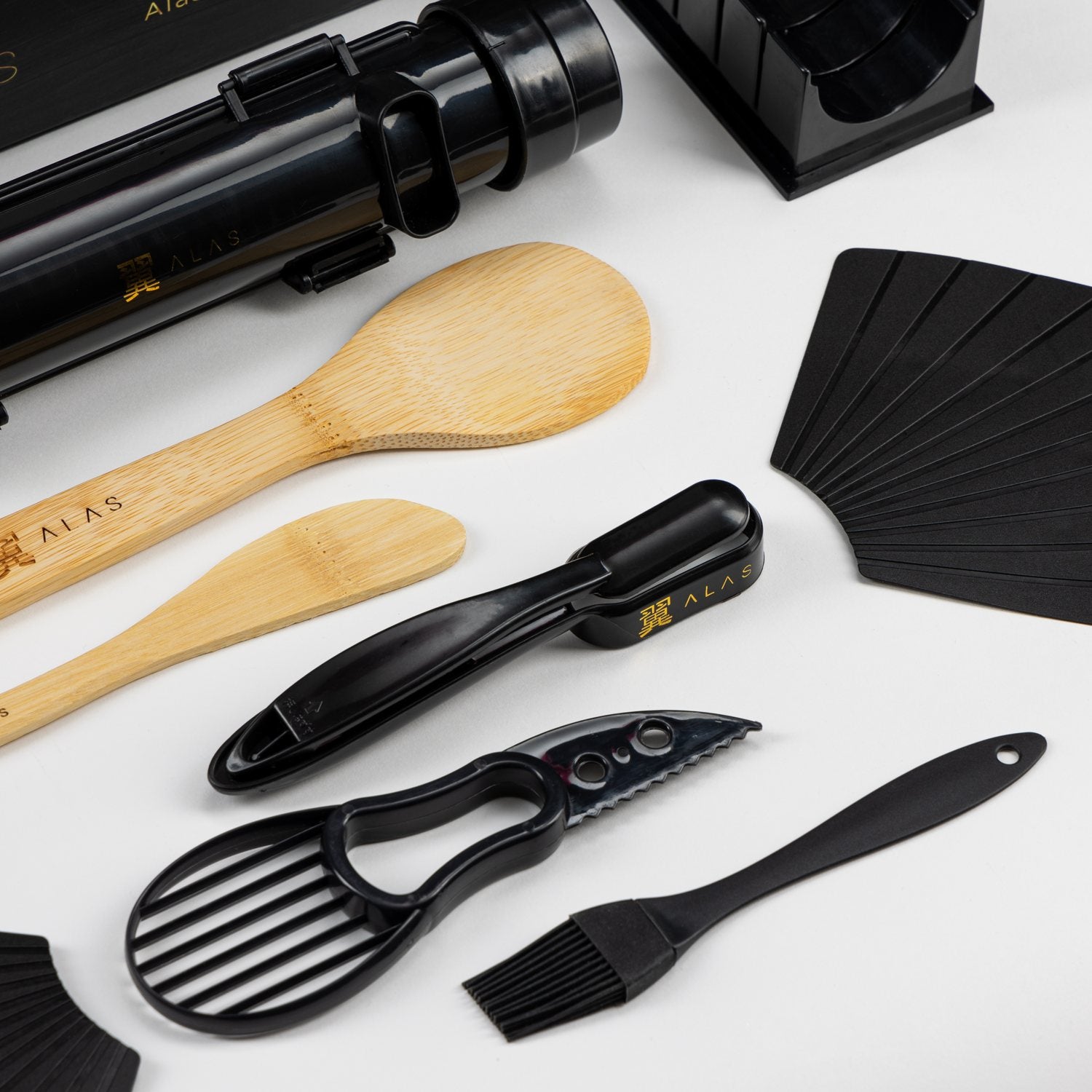 Black sushi bazooka, avocado slicer, brush and bamboo paddles