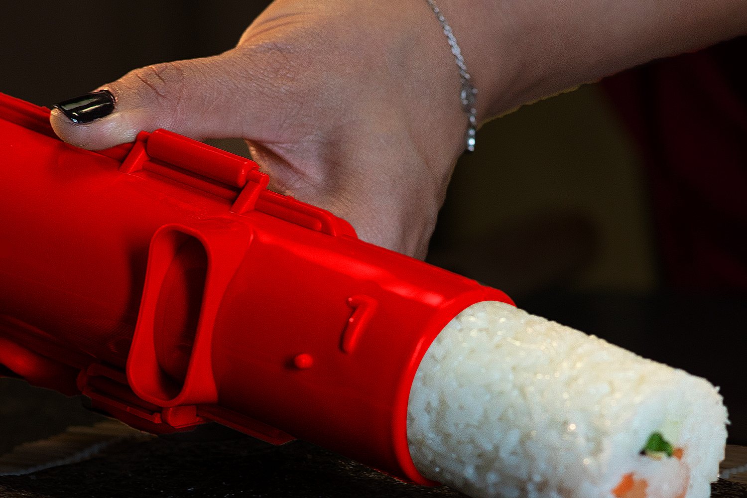 A finished roll coming out of the red sushi bazooka